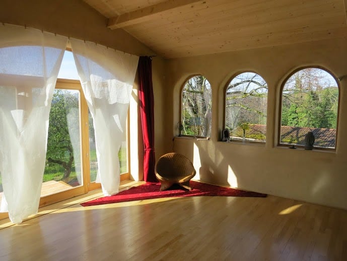 Tapis de yoga et zafu dans un magnifique dojo en bois, pour une retraite de yoga du cachemire. Photo en noir et blanc.